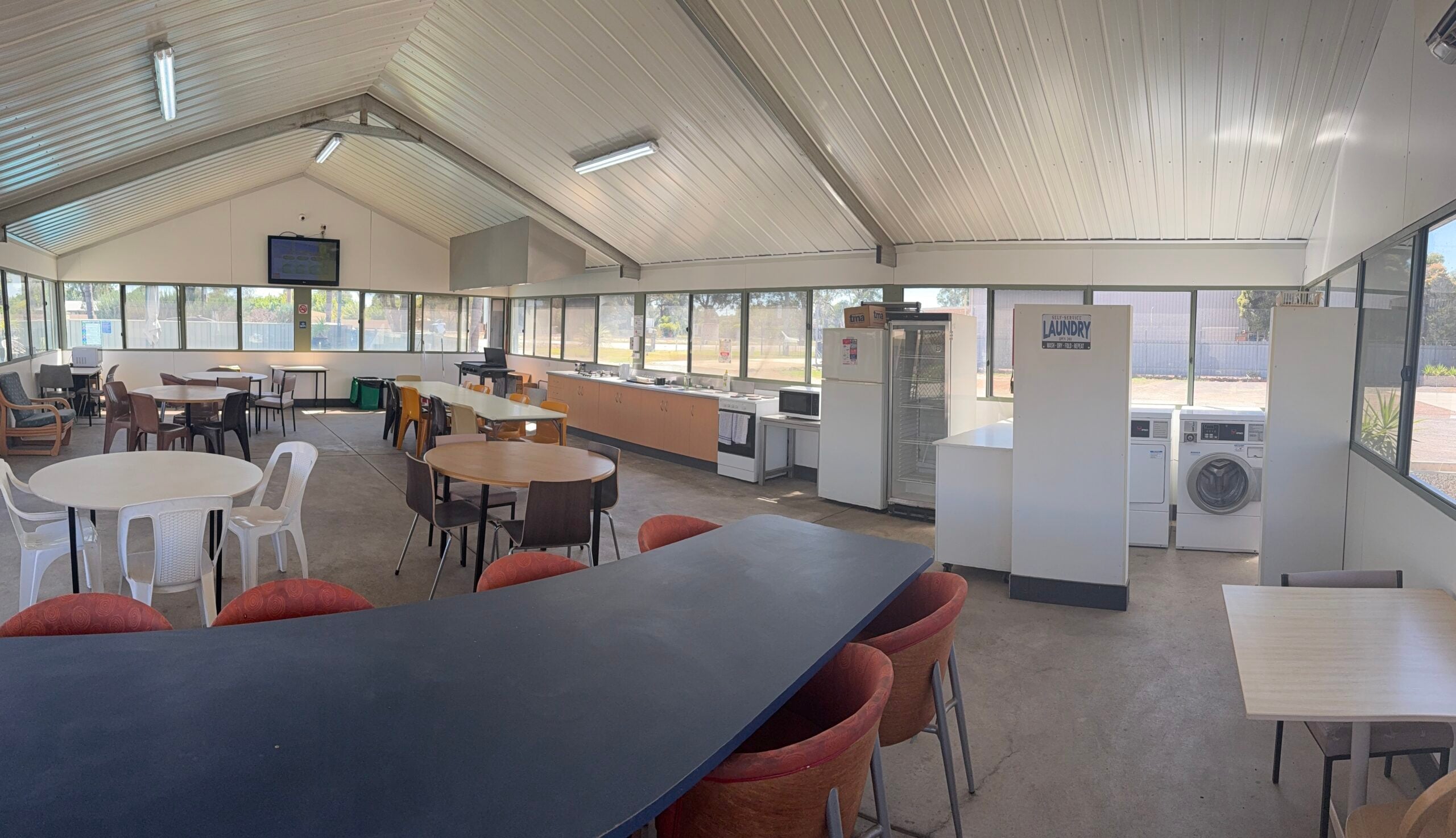 MIA Motel common kitchen with cooking facilities and shared dining tables